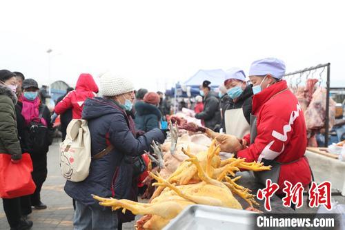 村民正在集市上选购年货。　于晶 摄