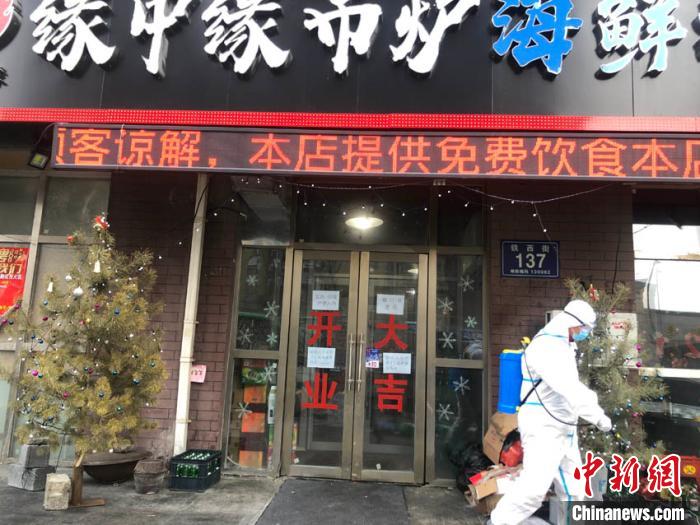 一位防疫人员路过王撼东的店。　孙博妍 摄