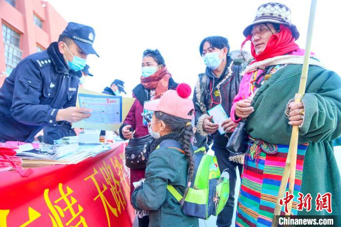 图为拉萨铁路公安民警向旅客发放乘车安全宣传资料。　黄飞 摄