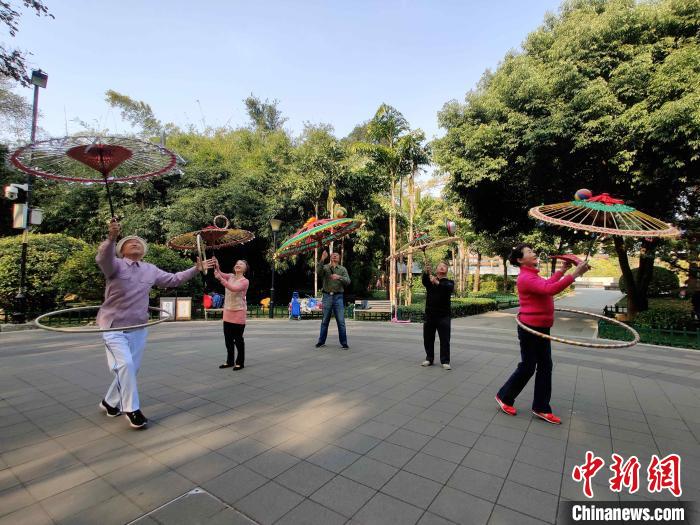 福州金瓯民间伞技队队员正在福州市温泉公园排练，吸引众人围观。　叶秋云 摄