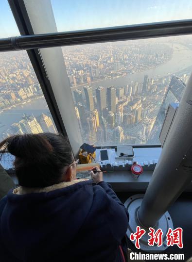 上海市民杜希贤在描绘沐浴在阳光下的城市高空景色，她说，“太阳每天都升起，每一天都是新的一天，人生不管以前碰到过什么，都没有关系，会来的也会走，包括疫情也是这样。” 郑莹莹 摄