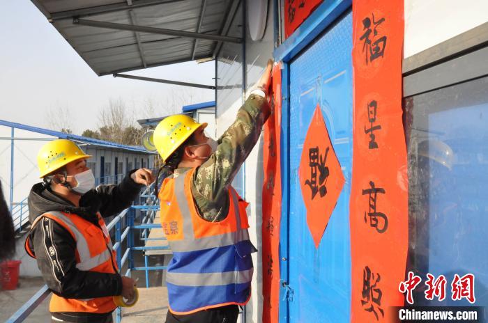 图为建设者为项目住处贴上春联 韩帅 摄