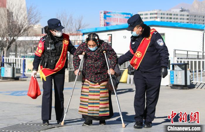 图为拉萨铁路公安民警帮助老人进站乘车。　胡安鹏 摄