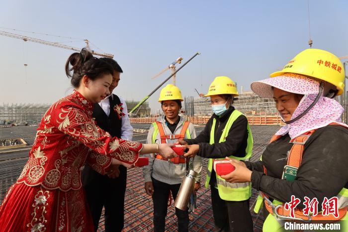 赣深高铁惠州北站项目工程部技术员刘建华带着妻子孙雨婷向工友敬茶 王建桥 摄