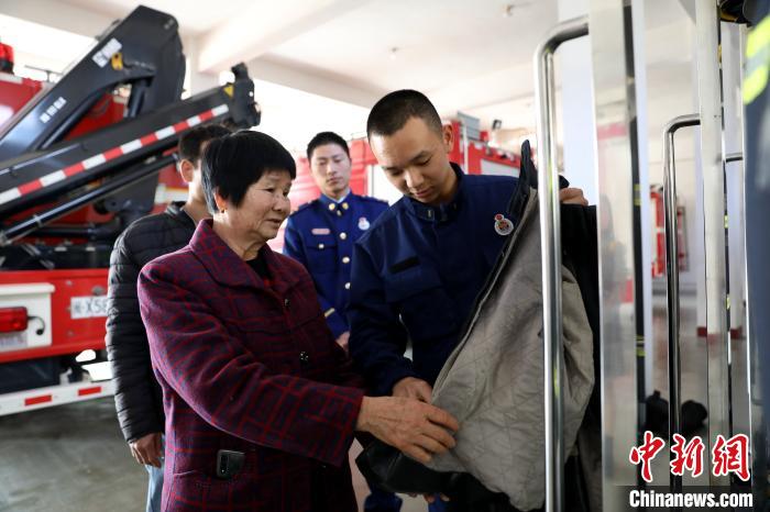 林芳艺为奶奶介绍灭火战斗服，林奶奶叮嘱孙儿出警一定要注意安全。　涂林发 摄