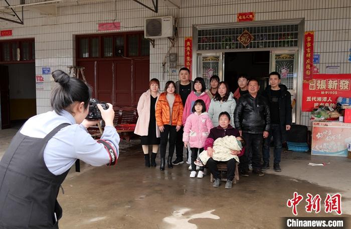 图为2月2日，“00后”大学生苏萌在湖南浏阳市永安镇永新村为乡亲们免费拍摄全家福，自1月24日开拍以来已拍了40余户。
中新社记者 王昊昊 摄