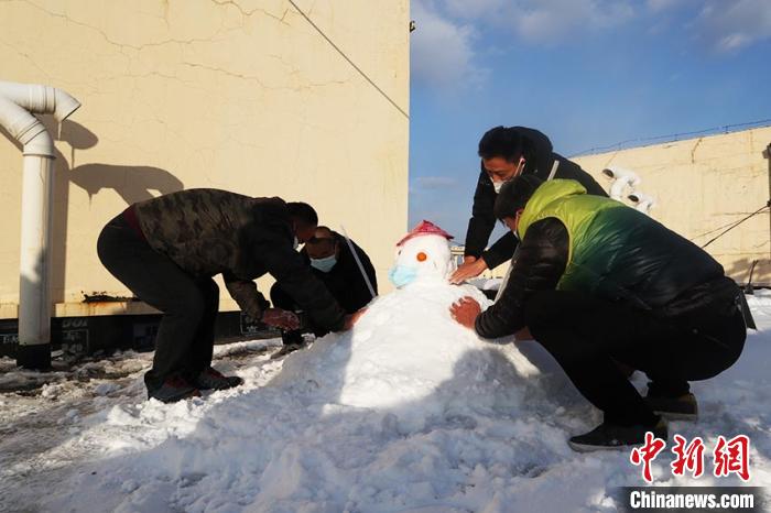 南方客人在酒店楼顶堆雪人 苍雁 摄