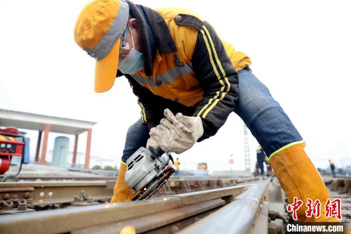 安康工务段职工正在对安康东站关键道岔接头部位进行修磨。　陈星衡 摄