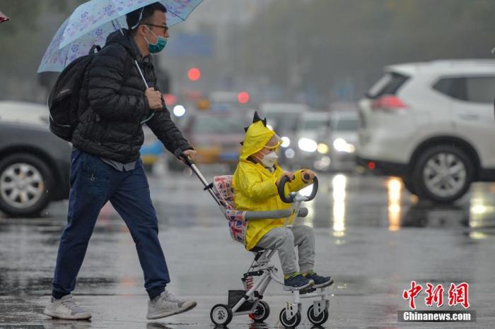 资料图：市民冒雨出行。
中新社记者 田雨昊 摄