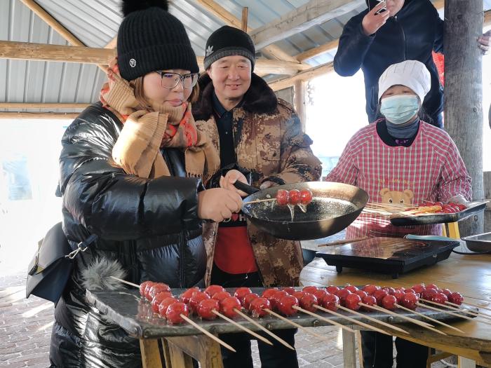 图为游客在冷极村制作糖葫芦。　张玮 摄