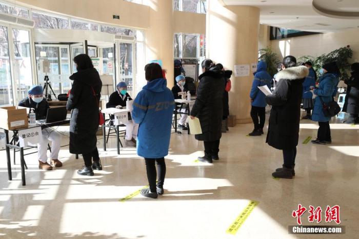 1月29日，在北京市海淀区学院路街道临时接种点内，等待接种疫苗的民众排队进行信息登记。近日，北京市海淀区重点人群新冠疫苗第二剂次接种工作开始有序进行。 中新社记者 蒋启明 摄