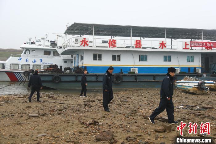 记者在见到熊宏伟的当天寒风刺骨，天空微微飘着小雨，但他与队友仍身穿护渔队制服，一步一脚印走在岸边进行日常巡护。　刘占昆 摄