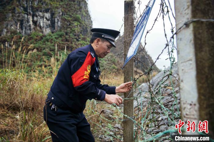 李军在修复破损的铁路防护网.　胡玄德 摄