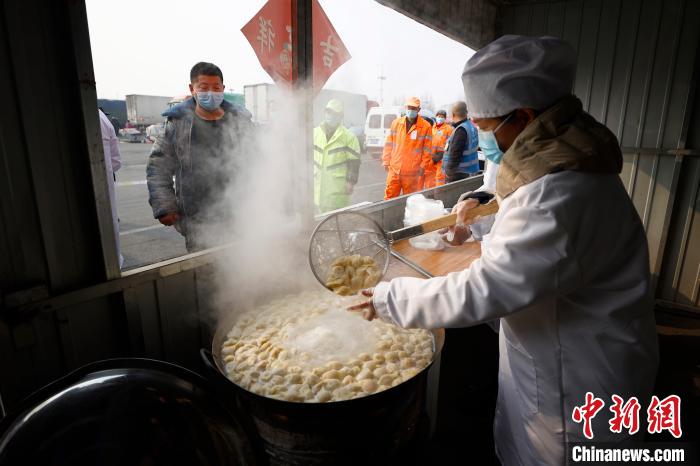 2月11日(农历除夕日)，北京新发地市场等共同采购10吨饺子和“新年礼包”，为留守商户煮饺子、送礼包。　富田 摄