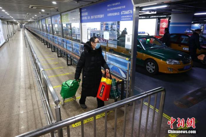 2月9日，一名旅客在北京南站出租车调度站乘车。中新社记者 富田 摄