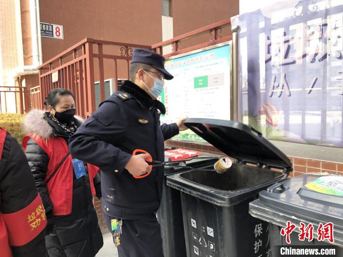 图为西宁市城中区生活垃圾分类推进办公室副主任孙向明在小区中进行垃圾分类。　祁绣娟 摄