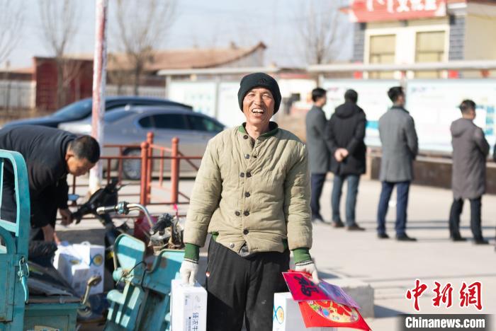 图为临近春节，村民刚刚领到慰问品，满脸高兴。　瑙甘塔拉 摄