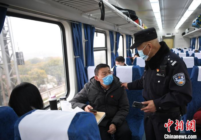 2月5日，乘警周彪在列车上与旅客交流。　韩苏原 摄