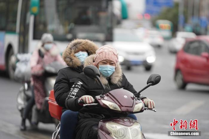 资料图：骑电动车的市民“全副武装”出行。中新社记者 刘冉阳 摄