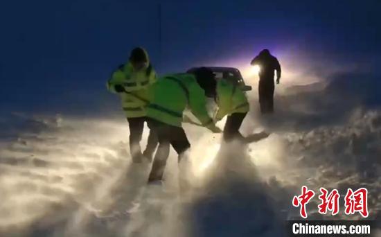 阿勒泰地区连日降雪，风吹雪导致车辆被困，交警连夜救援被困车辆。　阿勒泰交警支队提供 摄