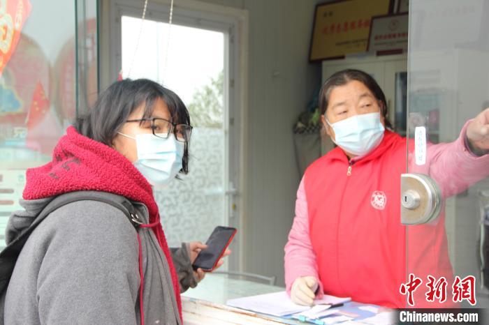 志愿者老奶奶正在耐心地为问路旅客讲解乘车路线。　李明明 摄