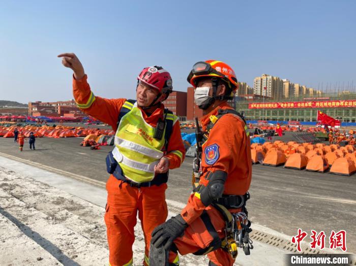 图为冯轶在向消防员介绍演练现场的地理环境。袁超 摄