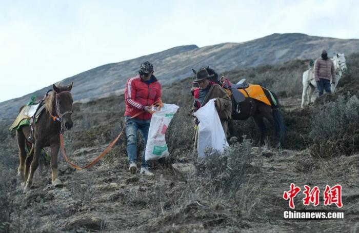 巡护队队员在高山上捡垃圾。刘忠俊 摄