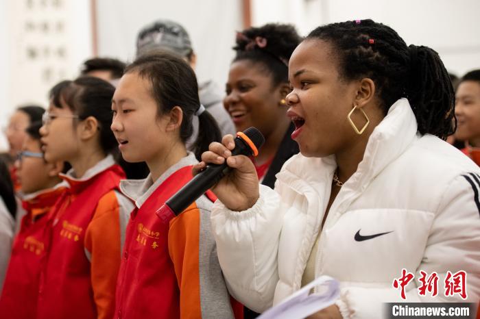 留学生与小学生们一起唱歌。　韦亮 摄