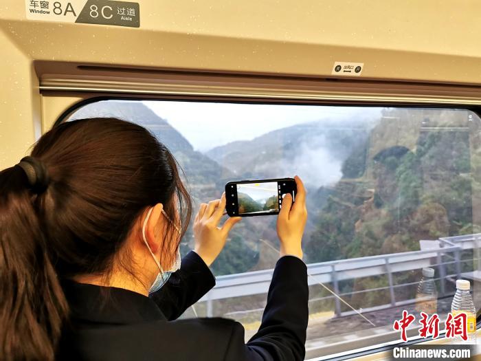 旅客坐在列车上拍摄沿途风景 郭爽 摄