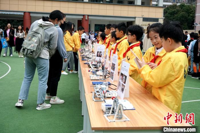 图为：学生们在操场上展示自己动手制作的机器人和智能应用设备。　叶秋云 摄