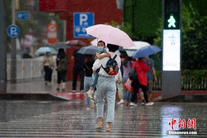 资料图：市民冒着大雨出行。
中新社记者 韦亮 摄