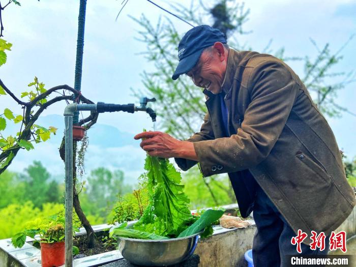 村民柳昌群用“飞线”引来的山泉洗菜。　周星亮 摄