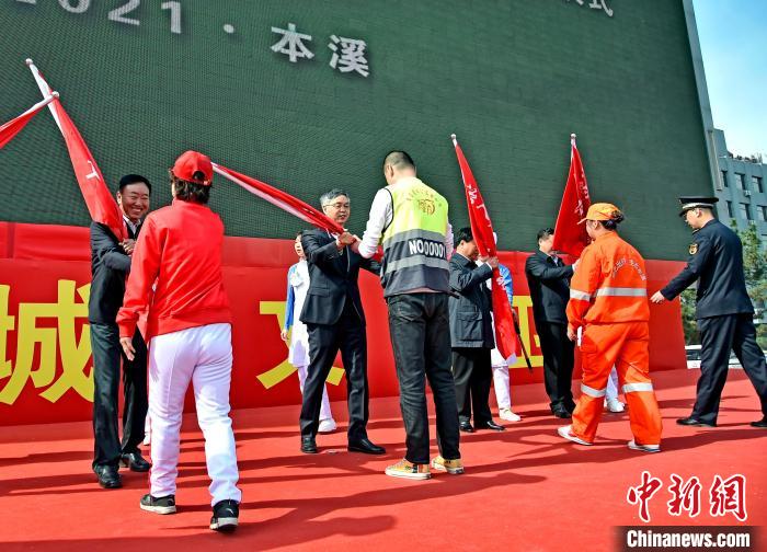 向“城市啄木鸟”等团队授旗。　李龙江 摄