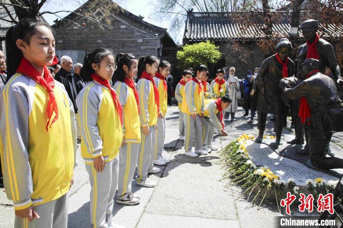 学生们为《英雄归来》雕塑敬献鲜花。　王莉 摄