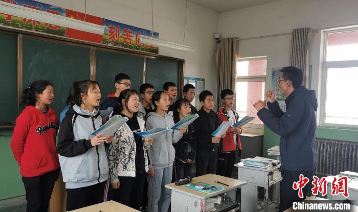 静乐县丰润中学音乐教师李晓斌正在给学生上音乐课。　杨杰英 摄