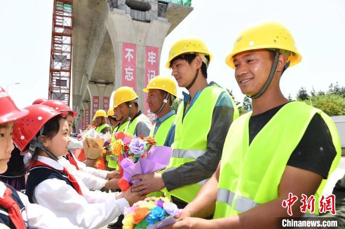 学生们给建设者送上自己制作的“手捧花”。　张大岗 摄