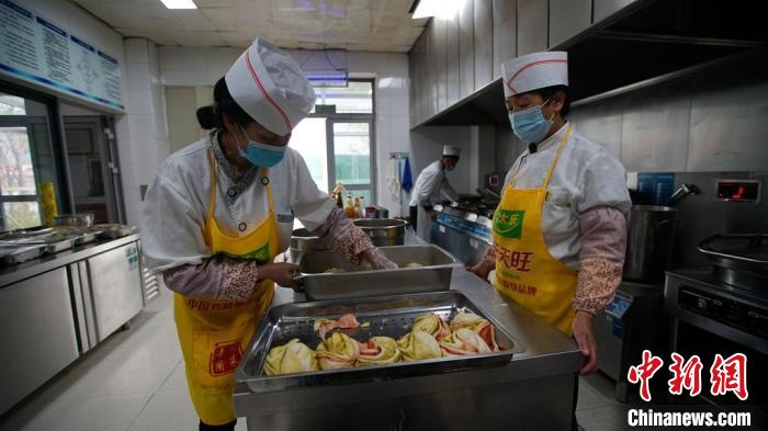 图为后勤工作人员为“电力天路”运检人员准备餐食。　朱毅然 摄