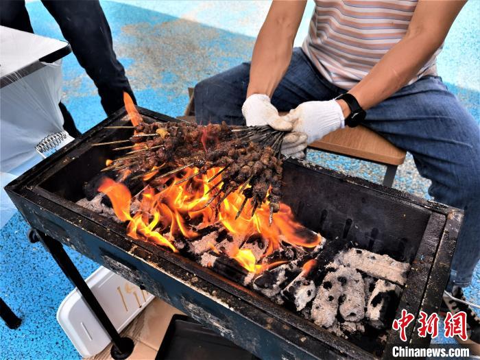 图为西宁市儿童福利院职工扮演的“烧烤摊主”正在烤的羊肉串。　祁增蓓 摄