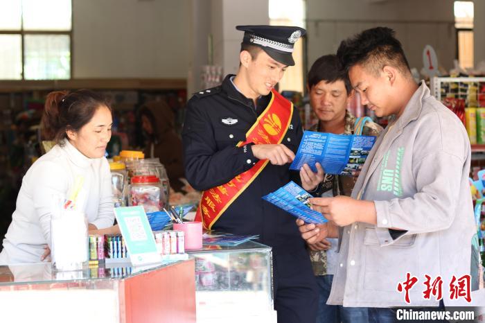 图为张忠虎向驻地老百姓讲解相关法律知识。　勐康边检站供图