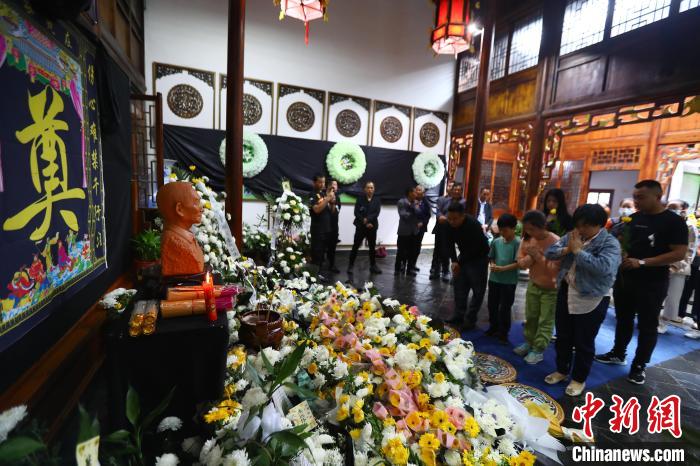 从各地冒雨赶来的民众手持鲜花依次走进馆内，向袁隆平雕像鞠躬致哀。　刘占昆 摄