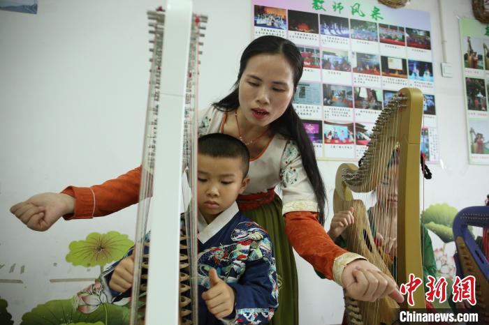 覃凤秋指导孩子练习演奏箜篌。　朱柳融 摄