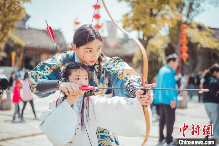 南京正心弓社的社员们教孩子们学习射箭。　李清影 摄