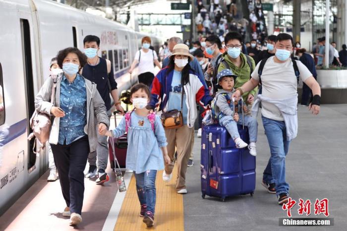 5月5日，江苏省南京市，旅客在南京火车站出行。中国国家铁路集团有限公司披露，当日全国铁路迎来“五一”假期返程客流高峰，预计发送旅客1720万人次，较2019年同期增长30���计加开旅客列车1736列。 　 中新社记者 泱波 摄