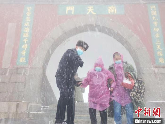 图为，泰安市公安局泰山景区分局岱顶派出所民警在风雪中执勤。(资料图) 岱顶派出所供图