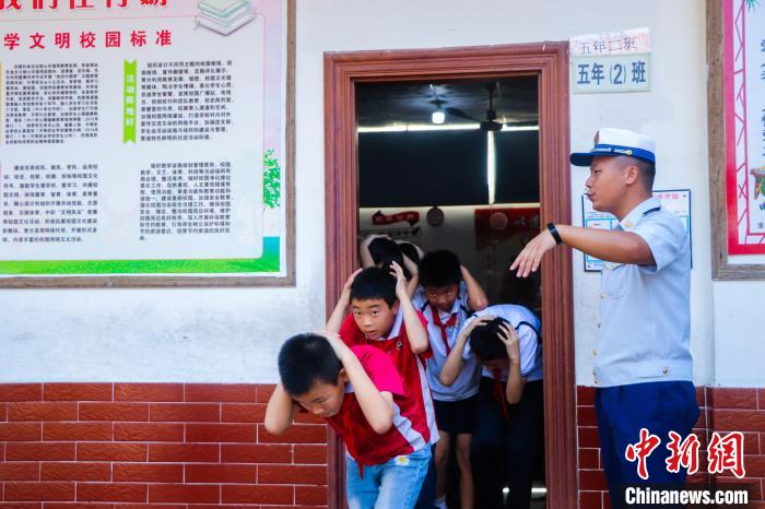 消防员正在组织学生进行地震疏散演练。　李袁辉 摄