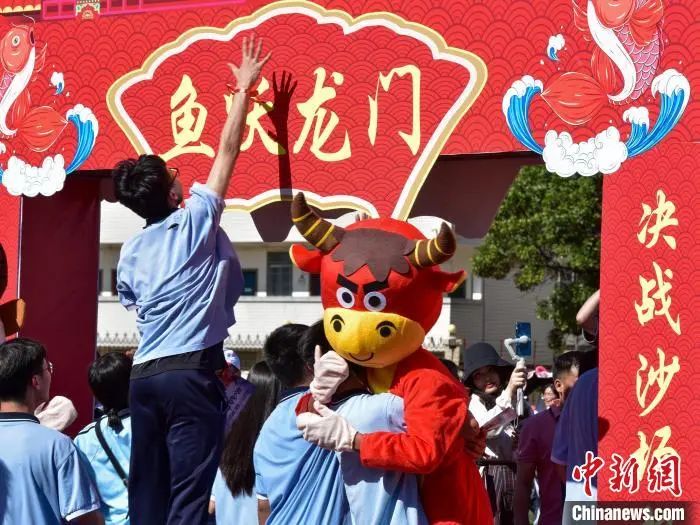 资料图：6月5日，广西柳州市柳江中学为高三学子举行高考“减压”活动。图为高三学生跳起“摸龙门”。　王以照 摄