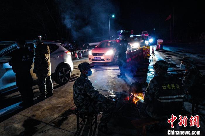 图为执勤人员在火塘边警戒、查车。　德宏边境管理支队供图 摄