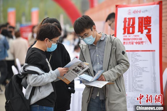 资料图：大学生翻看招聘简章。　武俊杰 摄