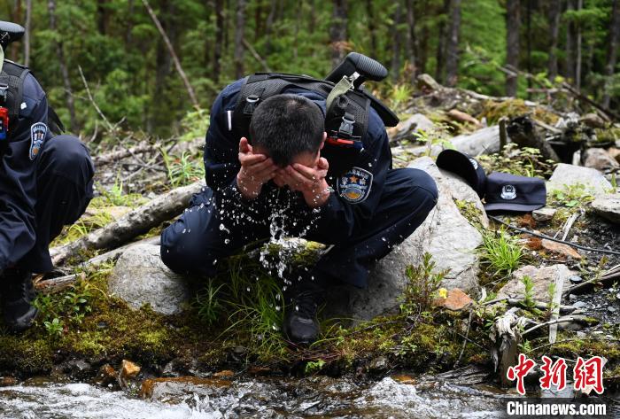 图为移民管理警察在溪边休息洗脸。　赵朗 摄