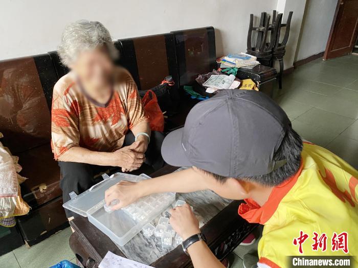 社区志愿者陈康杰专门上门帮助不识字的黄婆婆分配药品 广州市志愿者协会 供图